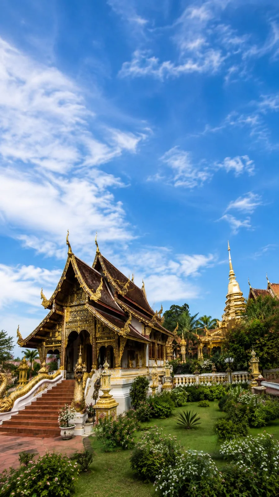 Templo tradicional decorado en oro bajo el cielo azul de Chiang Mai